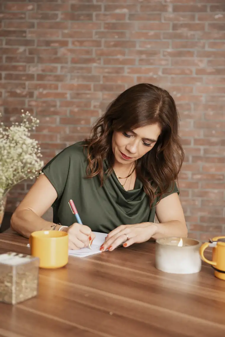 Cici escribiendo en su journal junto a una taza de té